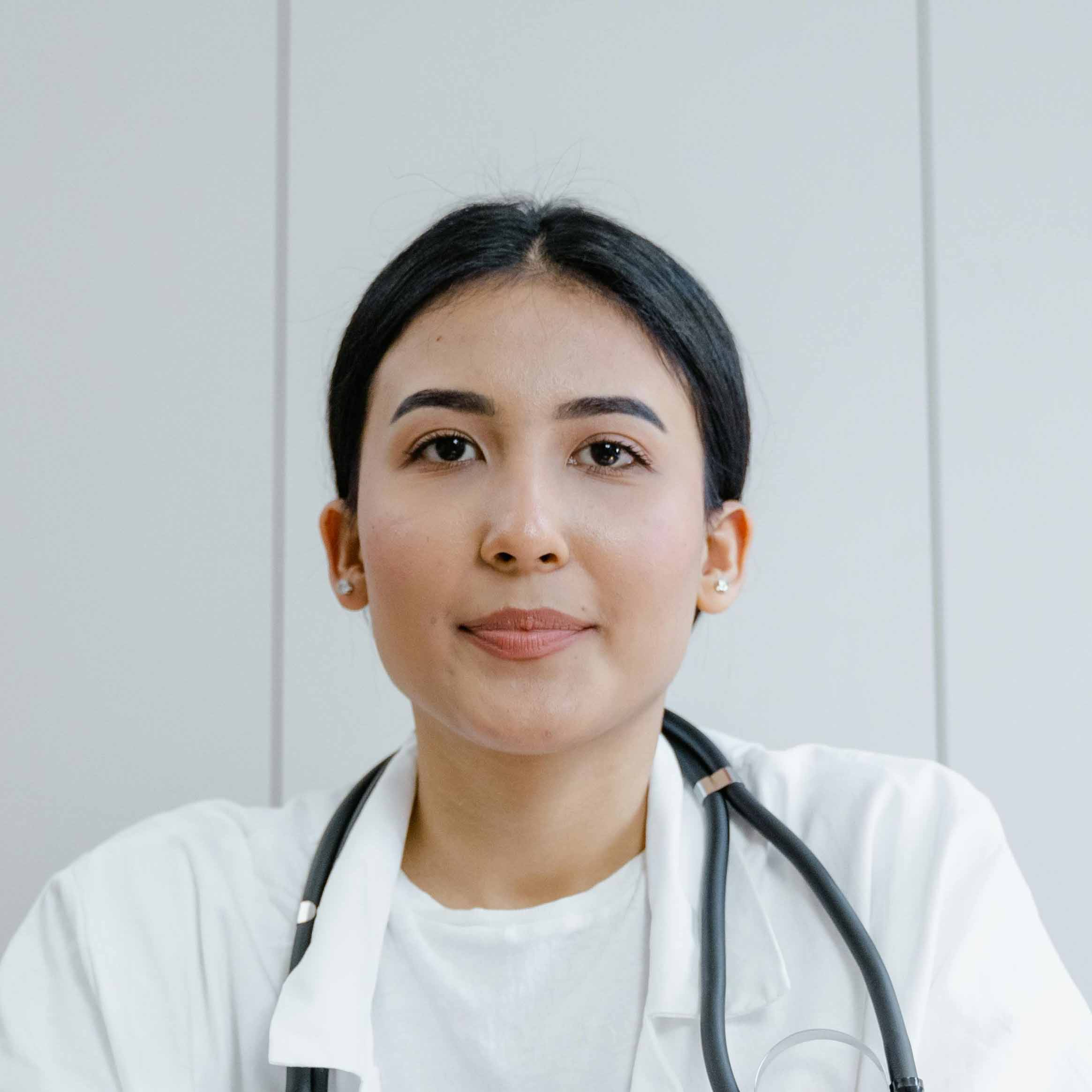 Doctor with a stethoscope around her neck looking at the viewer