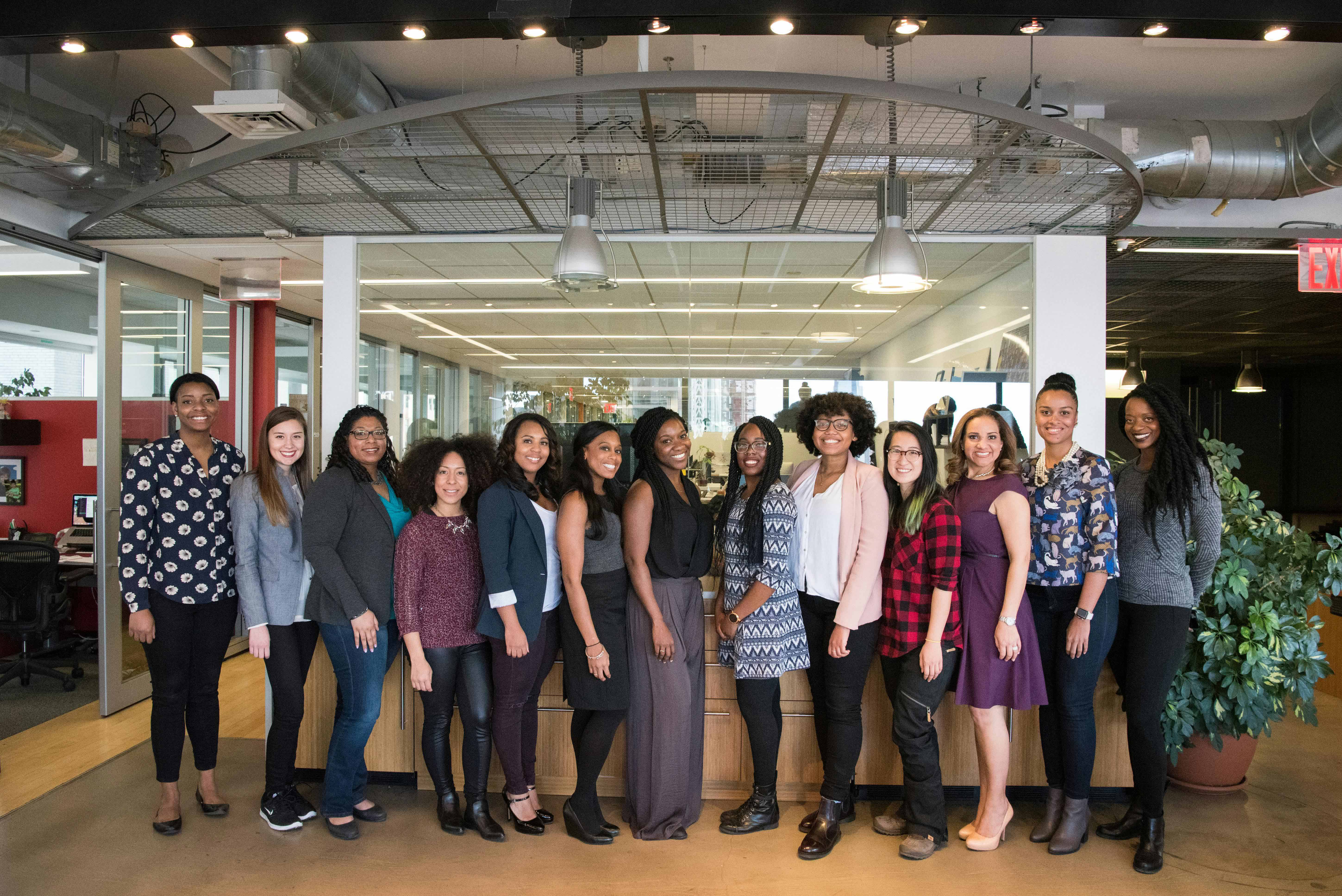 A group of women in business casual attire smiling for a photo