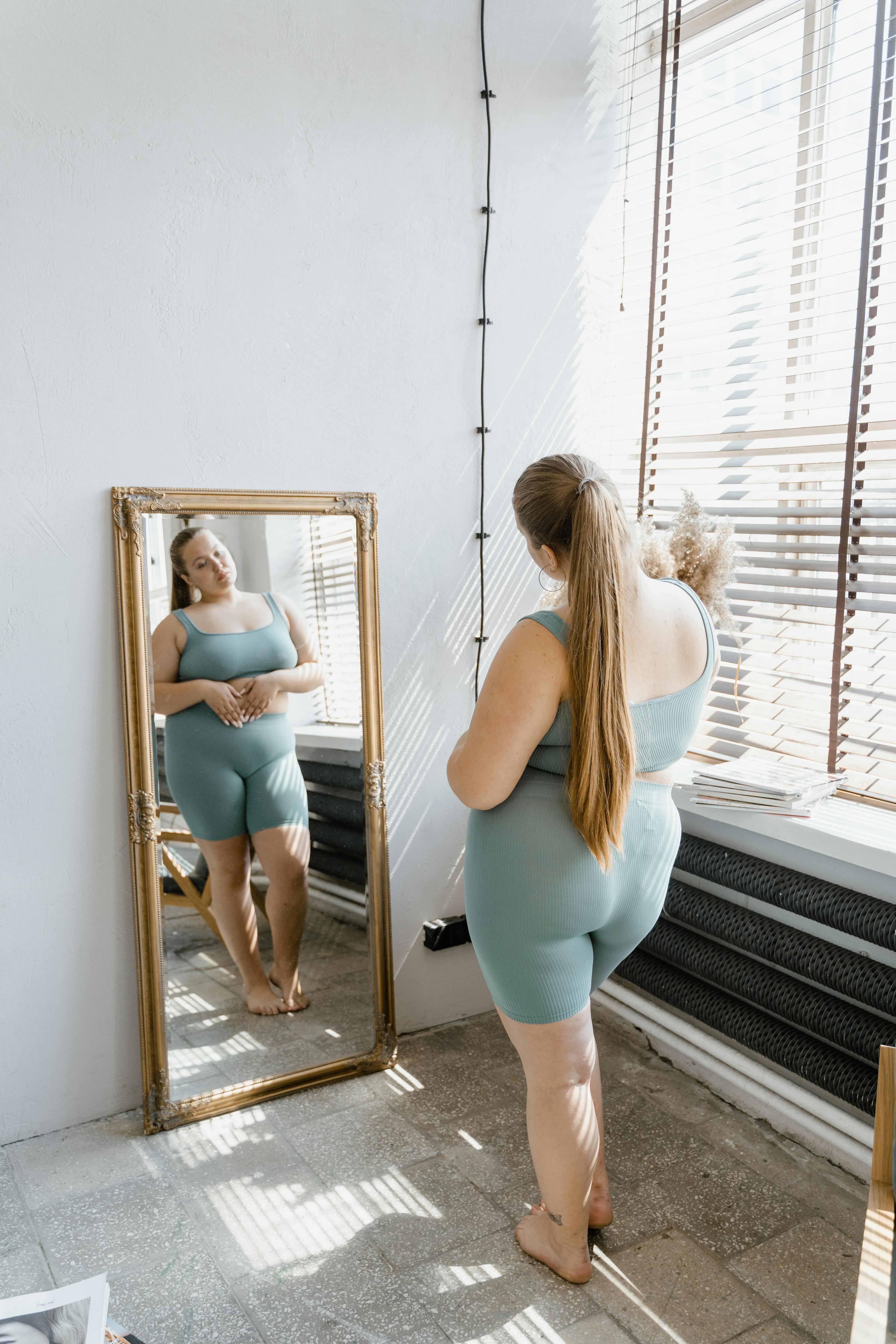 Woman looking at her self in the mirror in an apartment