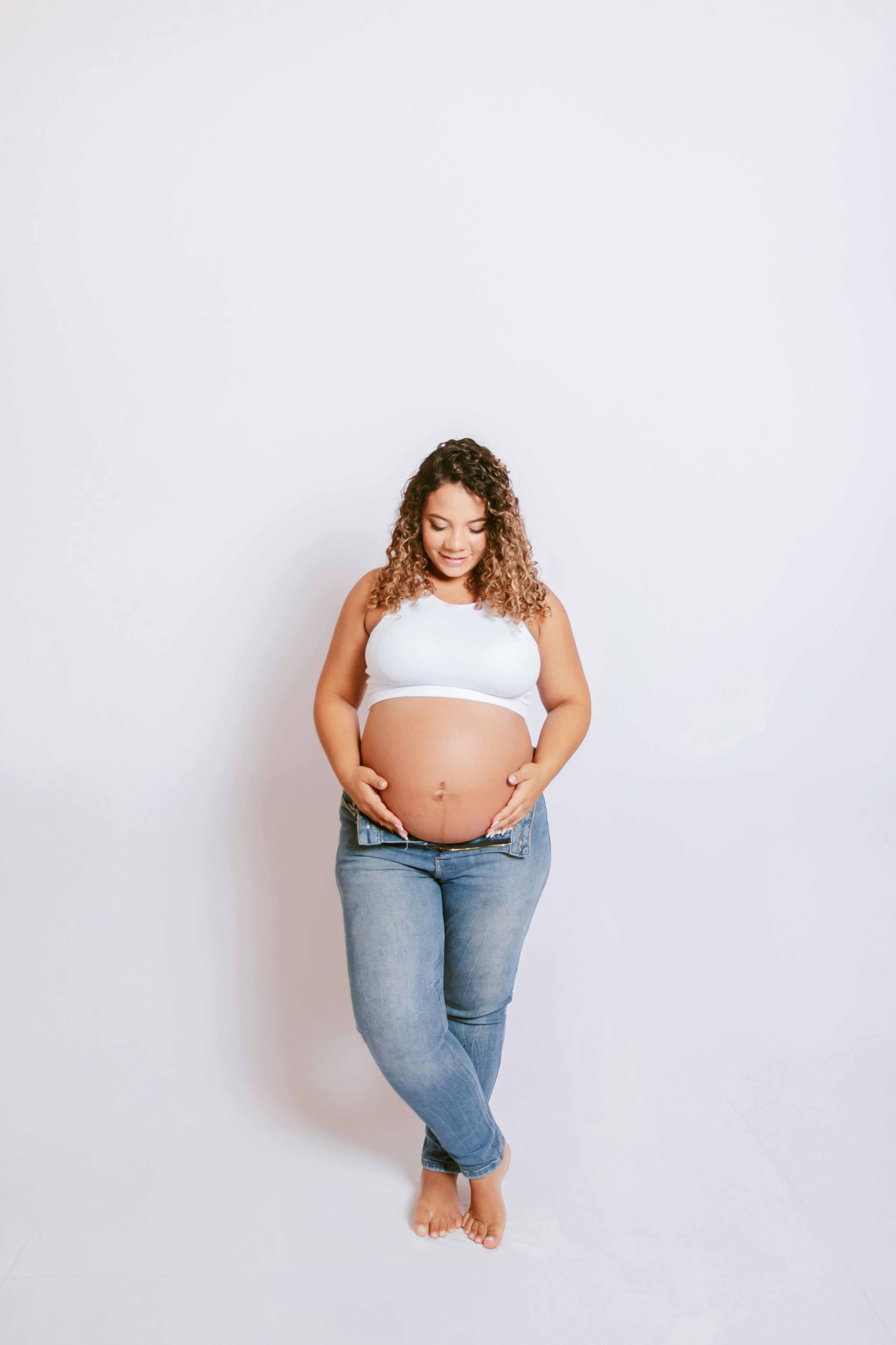 A pregnant woman gently holding her belly