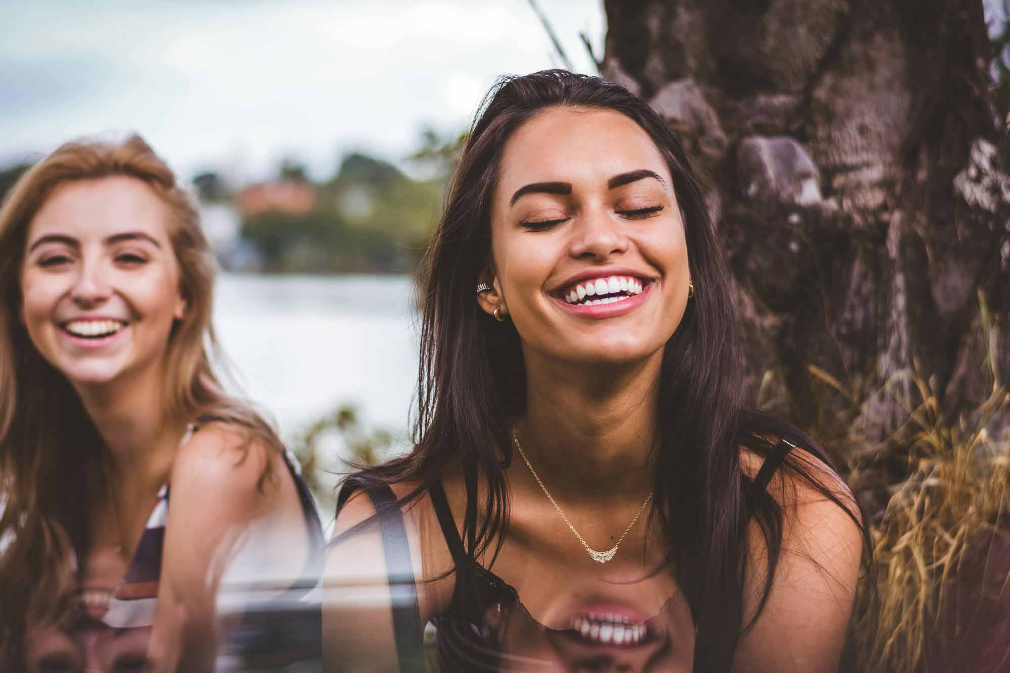 Two friends smiling and having a good time out in the sun