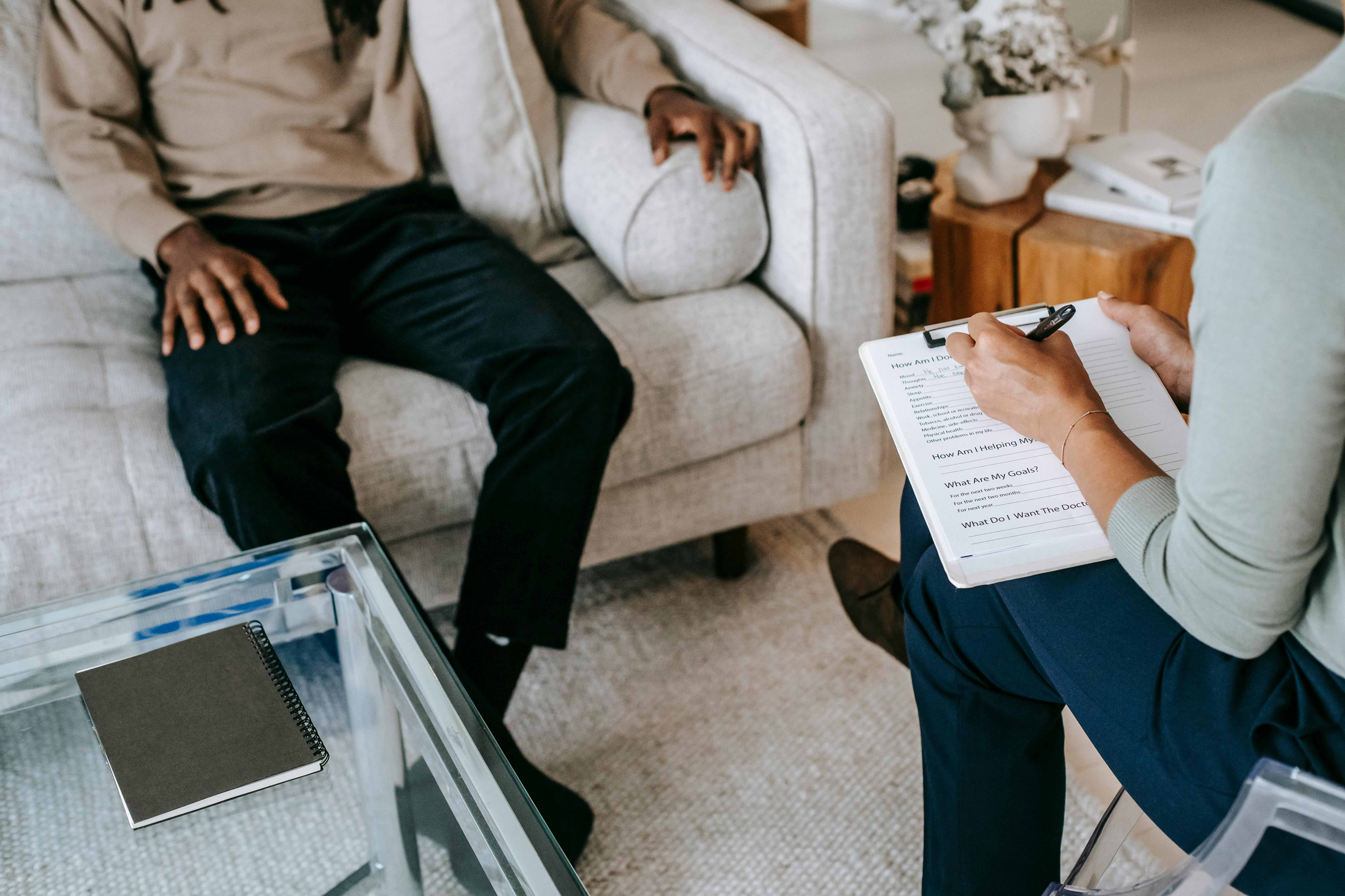 A therapist and a client engaged in a therapy session, discussing emotional well-being.