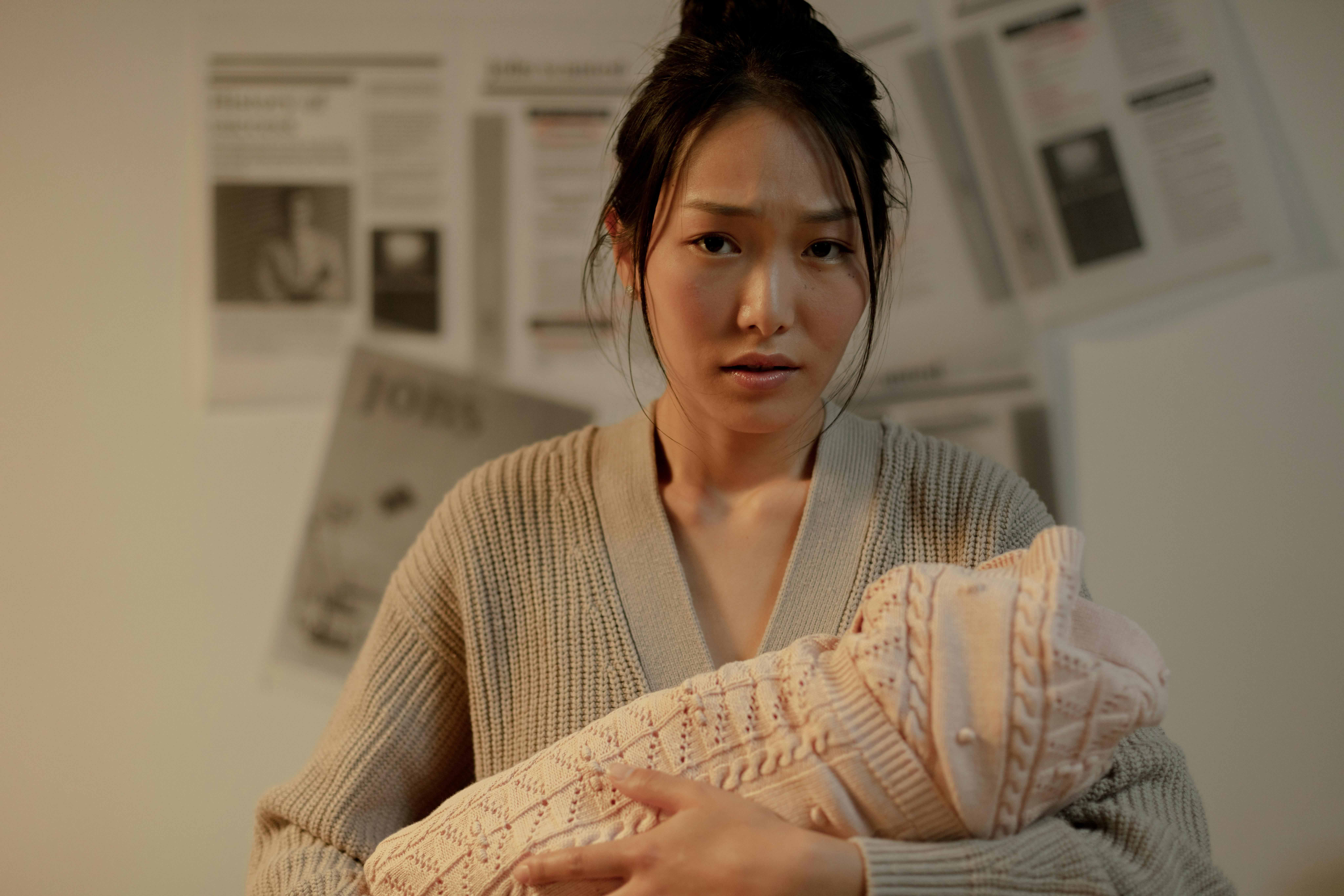 A person holding a baby in their arms looking at the view with a look of concern